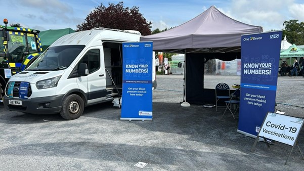 Picture of the One Devon 'Know Your Numbers' van and stall at a Covid-19 vaccination site.