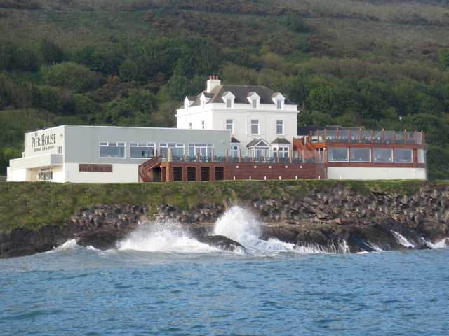 A building at the sea's edge, with large terraces either side.