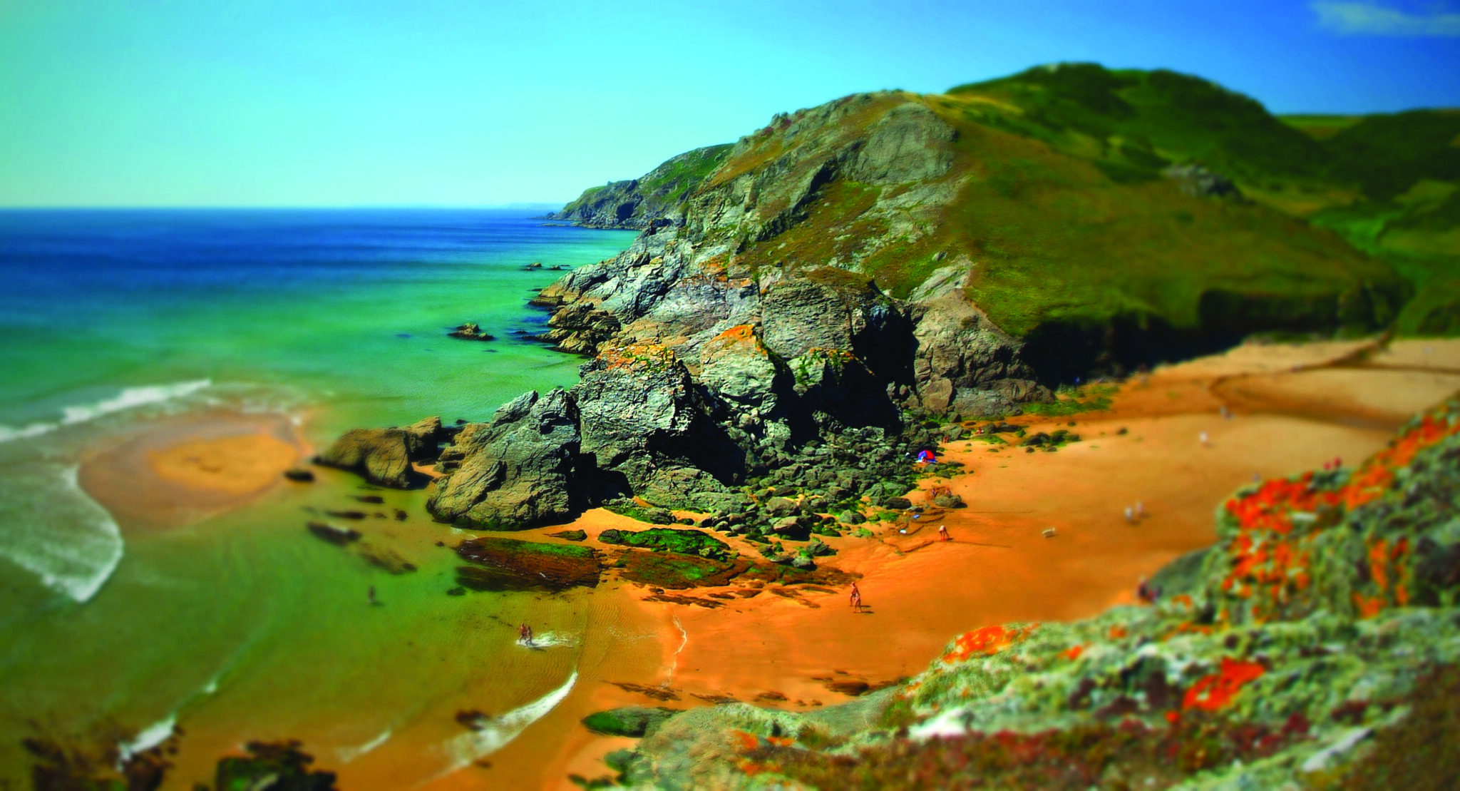 A sandy cove and sea seen from the clifftop