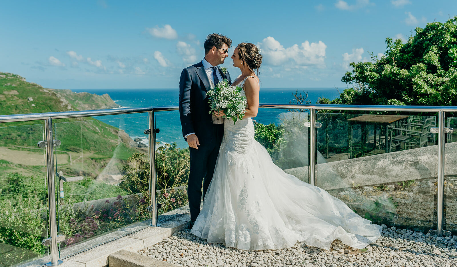 Emily and James at Gara Rock Wedding venue on a sunny day with the cliffs and sea behind them