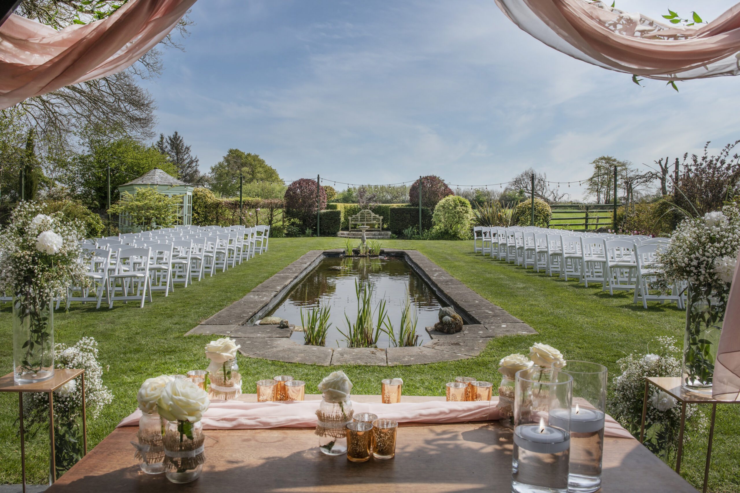 Glebe Cottages Devon , large pond with chairs set up for a wedding