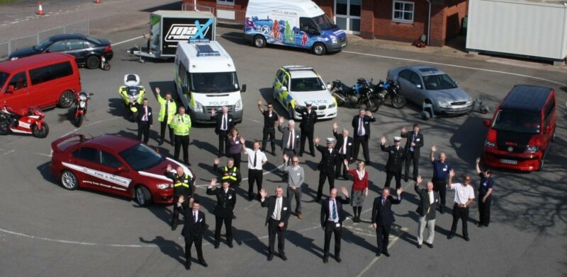 Photo of people waving who are a partnership of public, private and third sector organisations who work together for road safety.