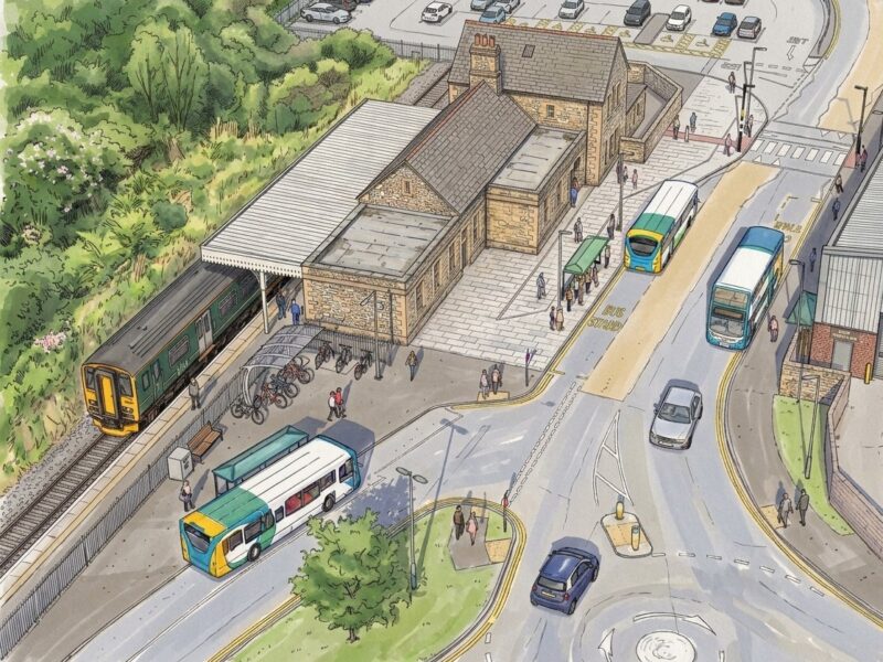 Artist's impression of planned scheme at Barnstaple Railway Station. Image shows buses using bus stops adjacent to the station, a train waiting to depart, cars using the road network (including a planned new mini-roundabout), pedestrians using the expanded forecourt and bus stops, a cycle shelter, a parallel crossing, and the station car park.