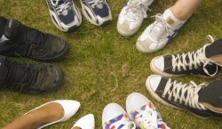 A close up of feet in a circle on grass