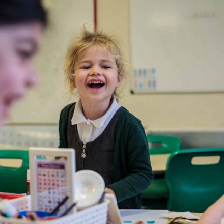 a young girl in a classroom looking happy