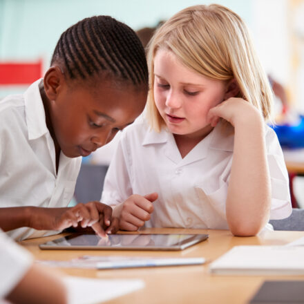 Two children of different ethnicities working together in a classroom