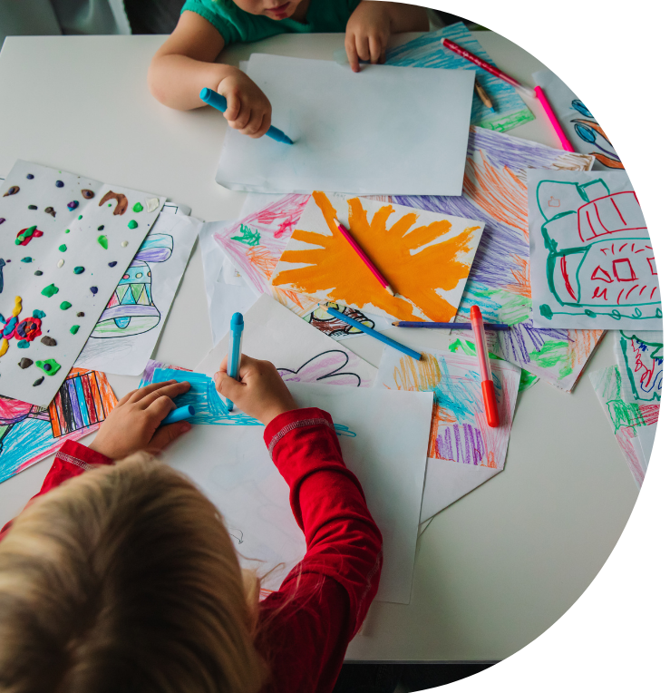 small children colouring in and drawing on paper on a table