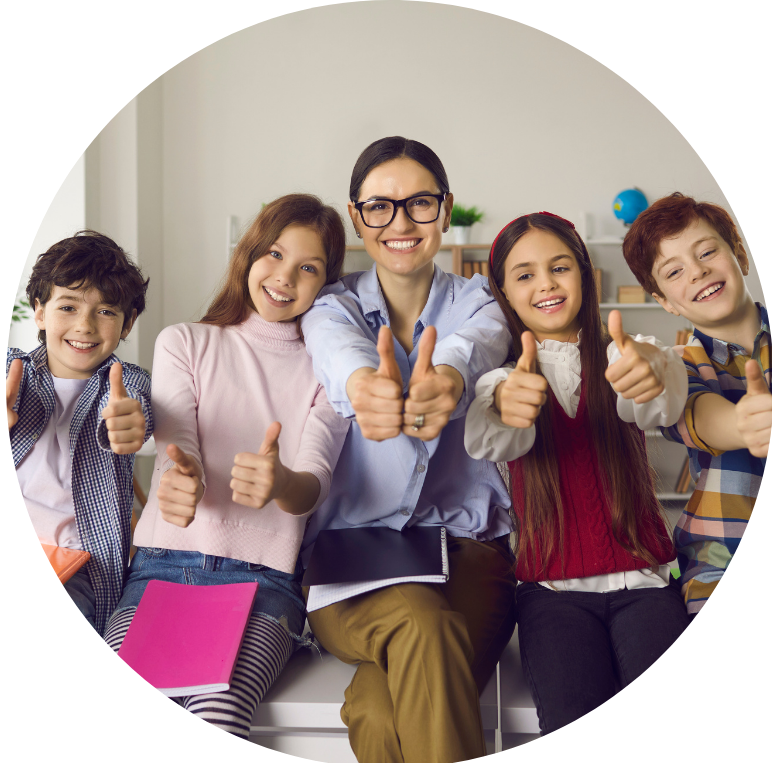 group of children sat with their teacher showing thumbs up to the camera