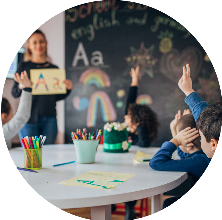 school kids in a classroom lesson with their hands up