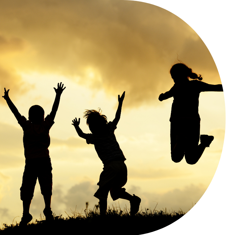 silhouette of children jumping in a field