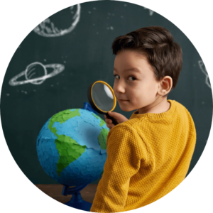 The image is cropped in a circle and shows a young child looking at a globe through a magnifying glass.