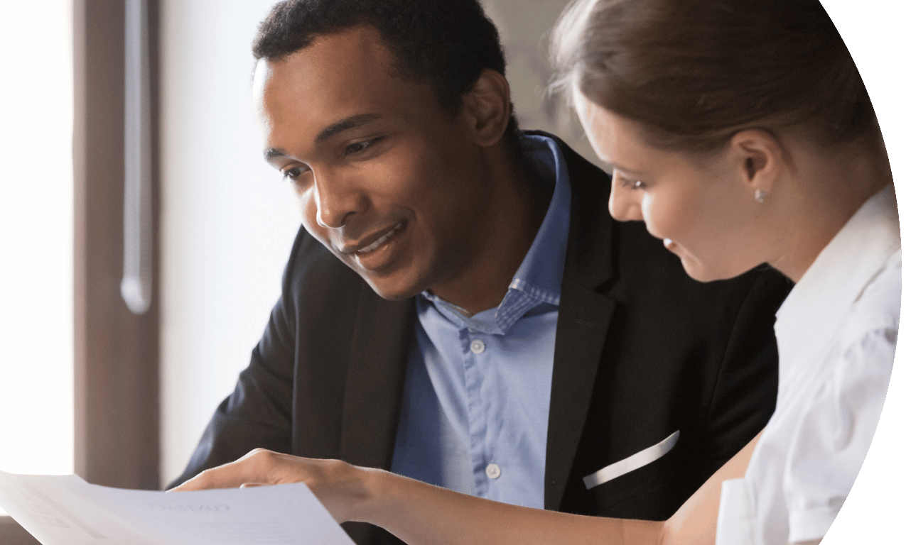 Two people looking at a document smiling.