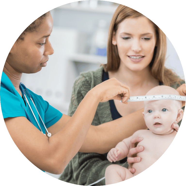 Image is cropped to a circle and shows a nurse measuring a babies head