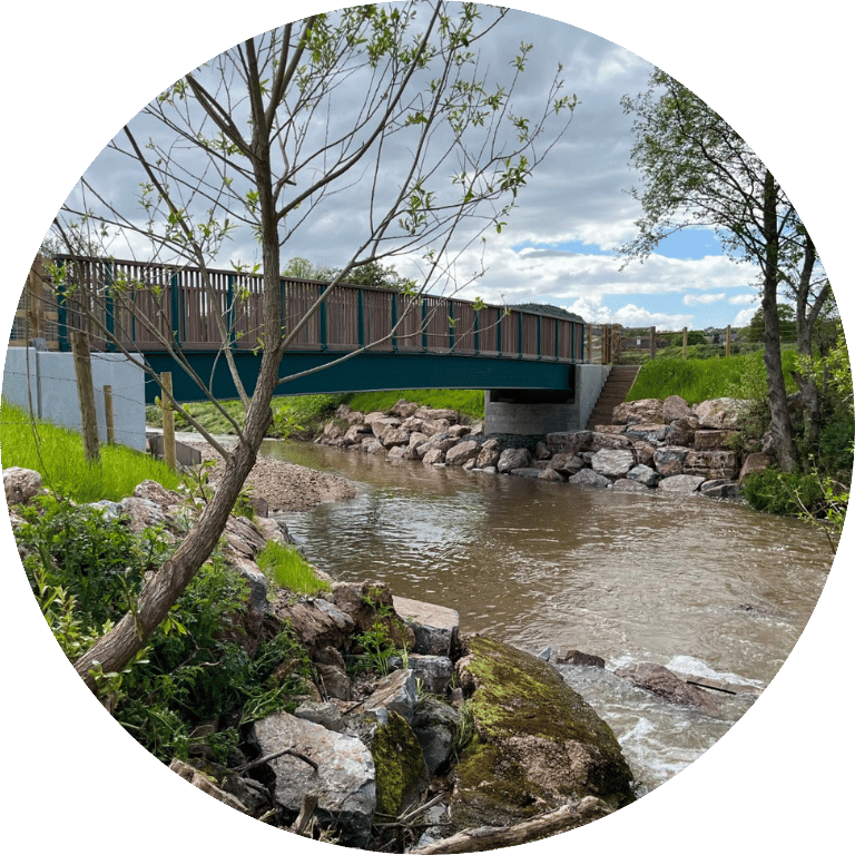Image is cropped to a circle and shows Skinners Farm Footbridge Replacement