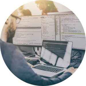 The image is cropped in a circle and shows the back of someone working on a laptop