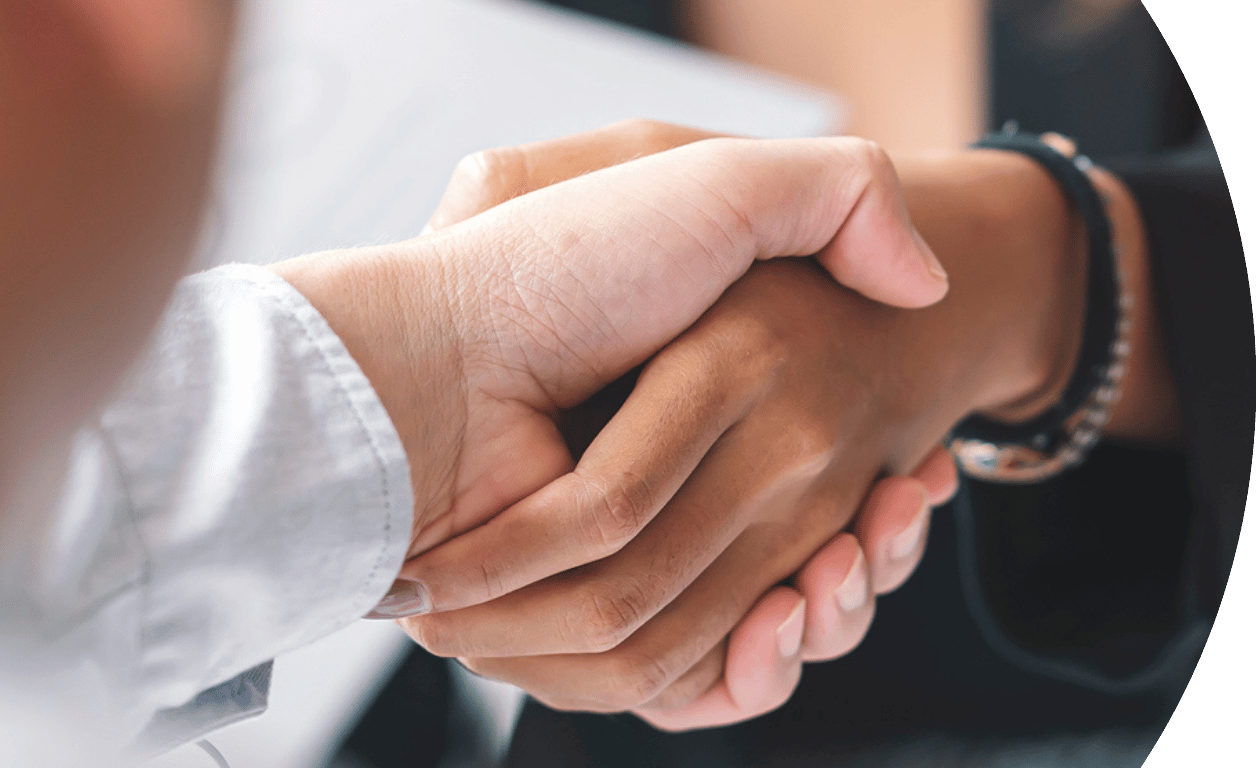 The image is curved on the left hand side and shows a close up of two people shaking hands.