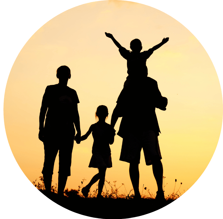 A family of four silhouetted against the sunset.