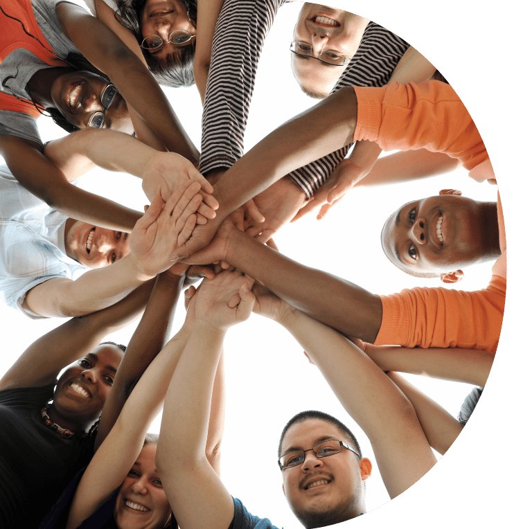 A group of people stood in a circle all holding hands.