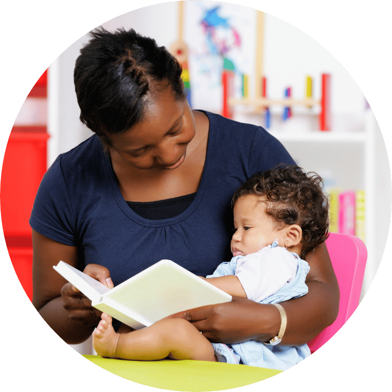 The image is cropped in a circle and shows person readding a book to a young child.