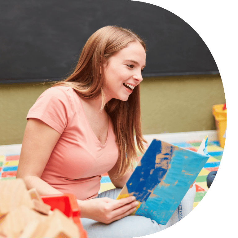 The image is cropped in a D shape and shows someone reading a book.