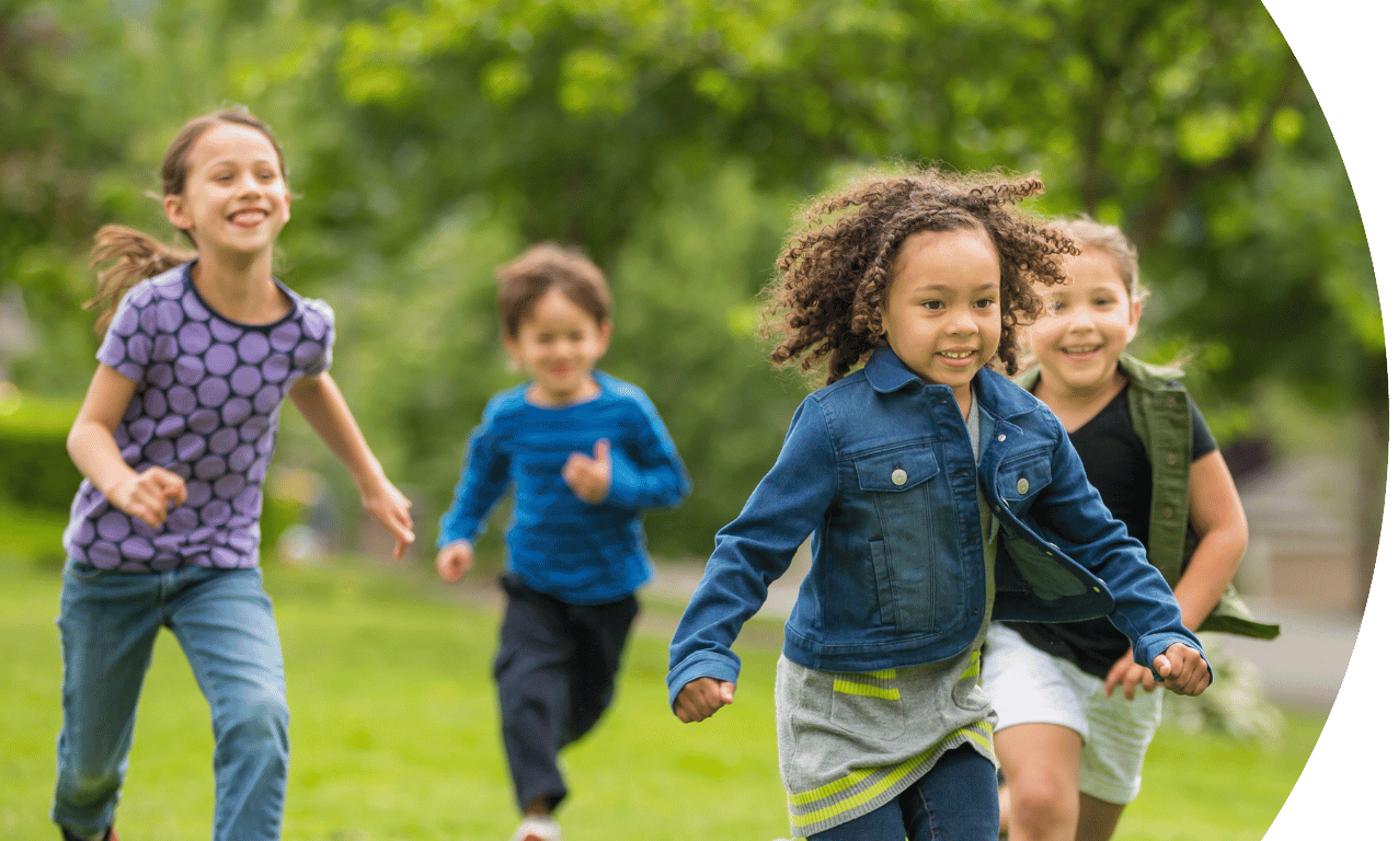 Four children running through the park.
