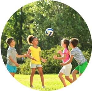 Picture of four children playing with a ball in the sun together.