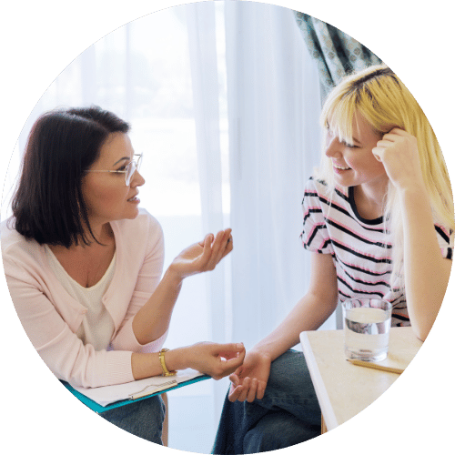 A person talking to a teenager