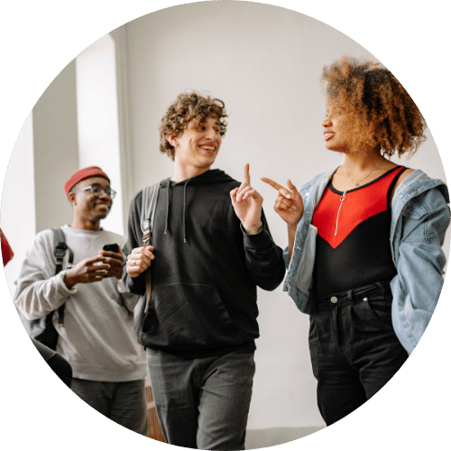Three people stood talking in a hallway.