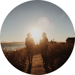 Two people walking away from the camera in an outdoor setting.