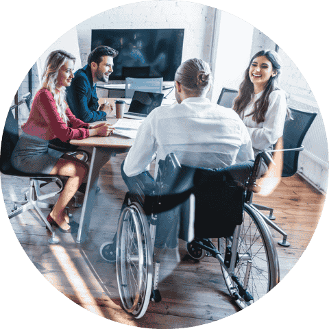 Image shows a group of four workers smiling and laughing at each other. The person closest to the camera is in a wheelchair