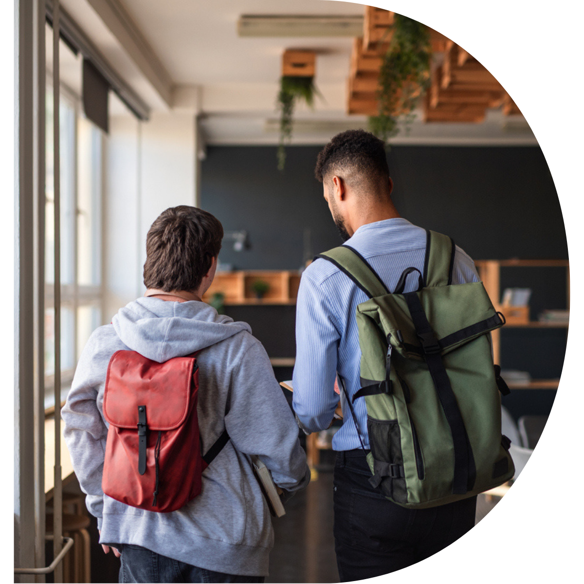 Picture of two young adults with backpacks facing away from the camera.