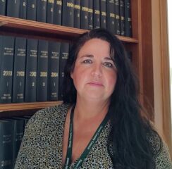 Maria Price, Director of Legal and Democratic Services, stood in front of a book case.